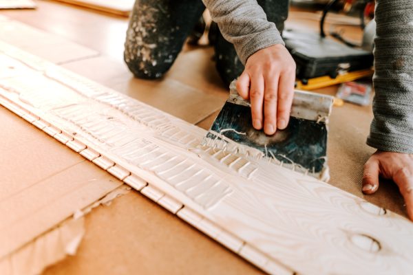 Worker laying and gluing parquet flooring