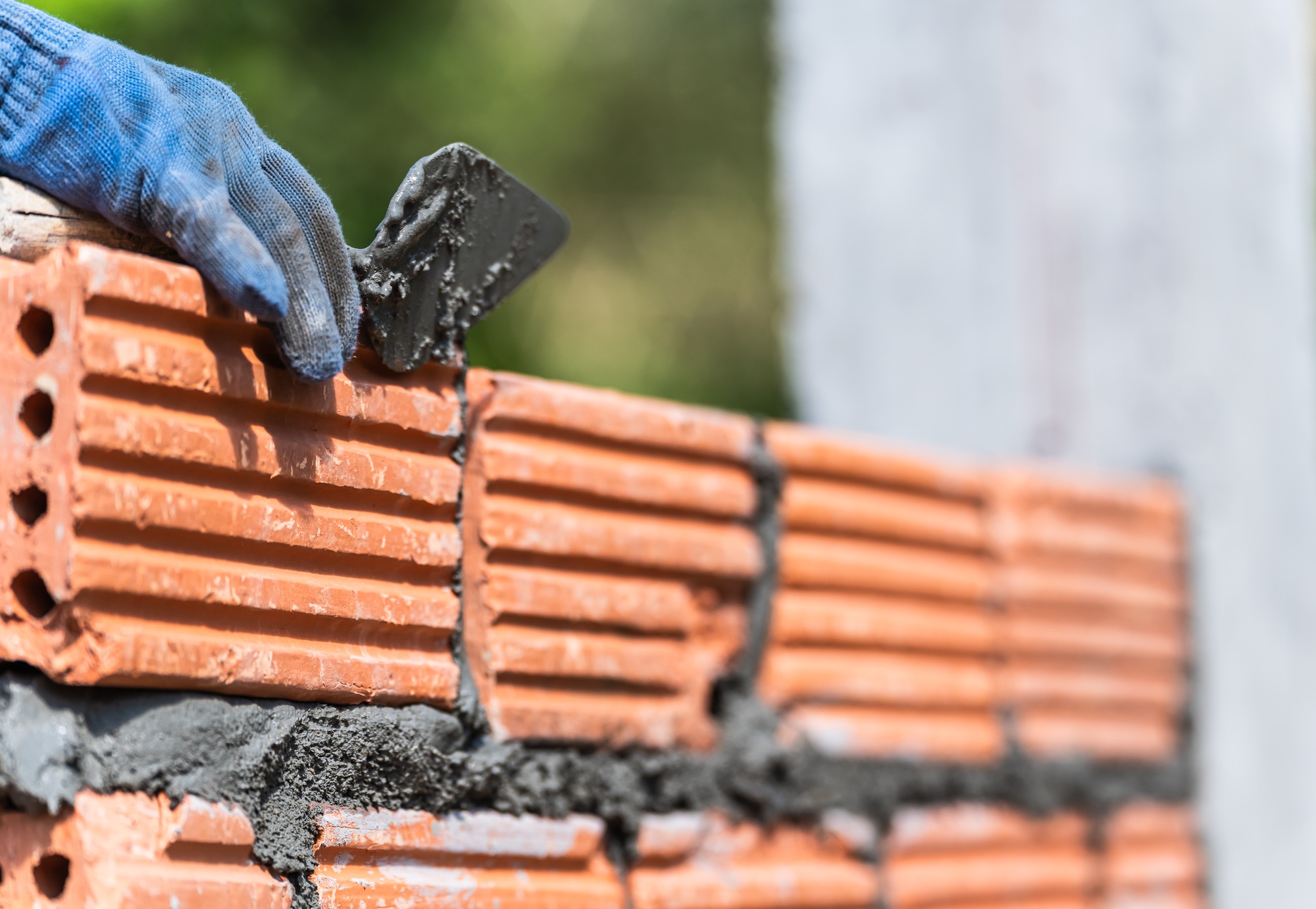 Hand worker masonry brickwork trowel construction site wall concrete background